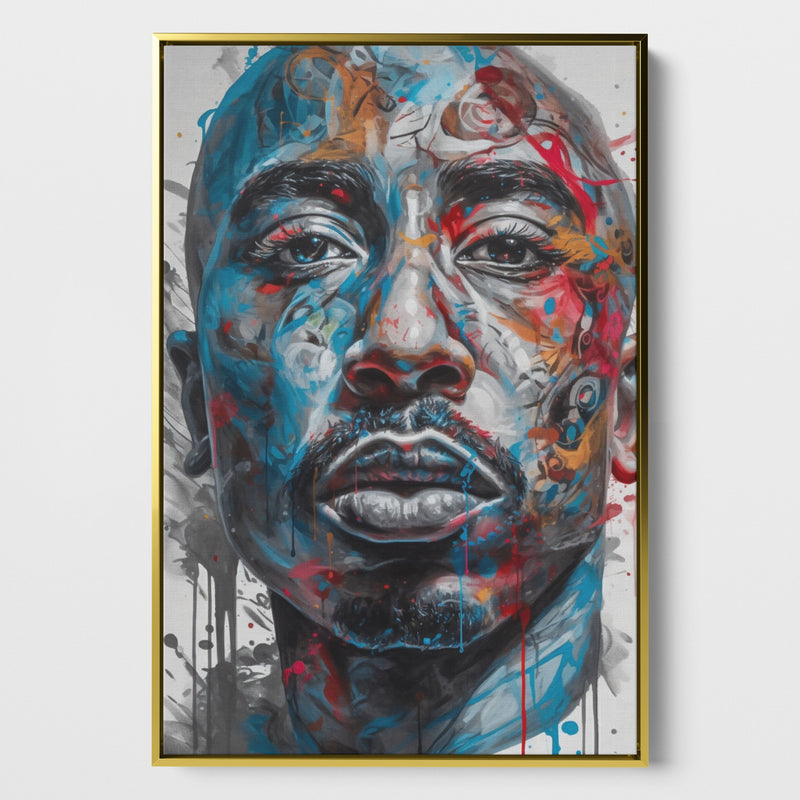 Das Bild zeigt ein lebendiges Porträt von Tupac Shakur mit expressiven, farbenfrohen Akzenten auf einer Leinwand. Der Stil des Kunstwerks ist modern und wirkt fast wie eine Fusion aus Realismus und abstrakter Kunst. Die Farben Blau und Rot dominieren, wobei dynamische Farbspritzer und Ströme über das Gesicht laufen, was dem Bild Energie und Bewegung verleiht. Das Bild ist eingerahmt in einem goldenen Schattenfugenrahmen.