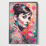 Das Bild zeigt ein Porträt von Audrey Hepburn im Pop-Art-Stil mit einem lebendigen Farbspektrum aus Rosa-, Orange- und Blautönen. Das Gesicht der Frau ist detailliert und realistisch mit einem subtilen Lächeln und sanft blickenden Augen dargestellt. Ihr Haar ist zu einem hohen Knoten gestylt, und durchscheinende Farbkleckse überlagern das Bild, was dem Werk eine spielerische und künstlerische Atmosphäre verleiht. Das Leinwandbild ist eingerahmt in einen silbernen Schattenfugenrahmen.